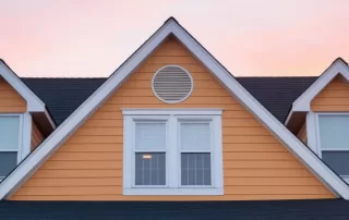 traditional home roof against a sunset background
