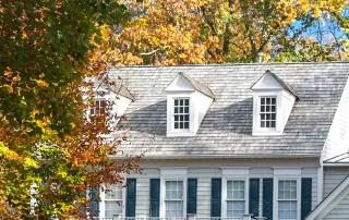 a stately and traditional home surrounded by trees in the fall and autumn