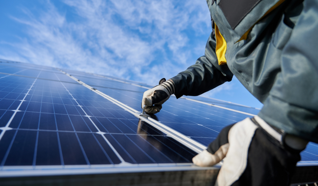 A person installing solar panels on a roof.